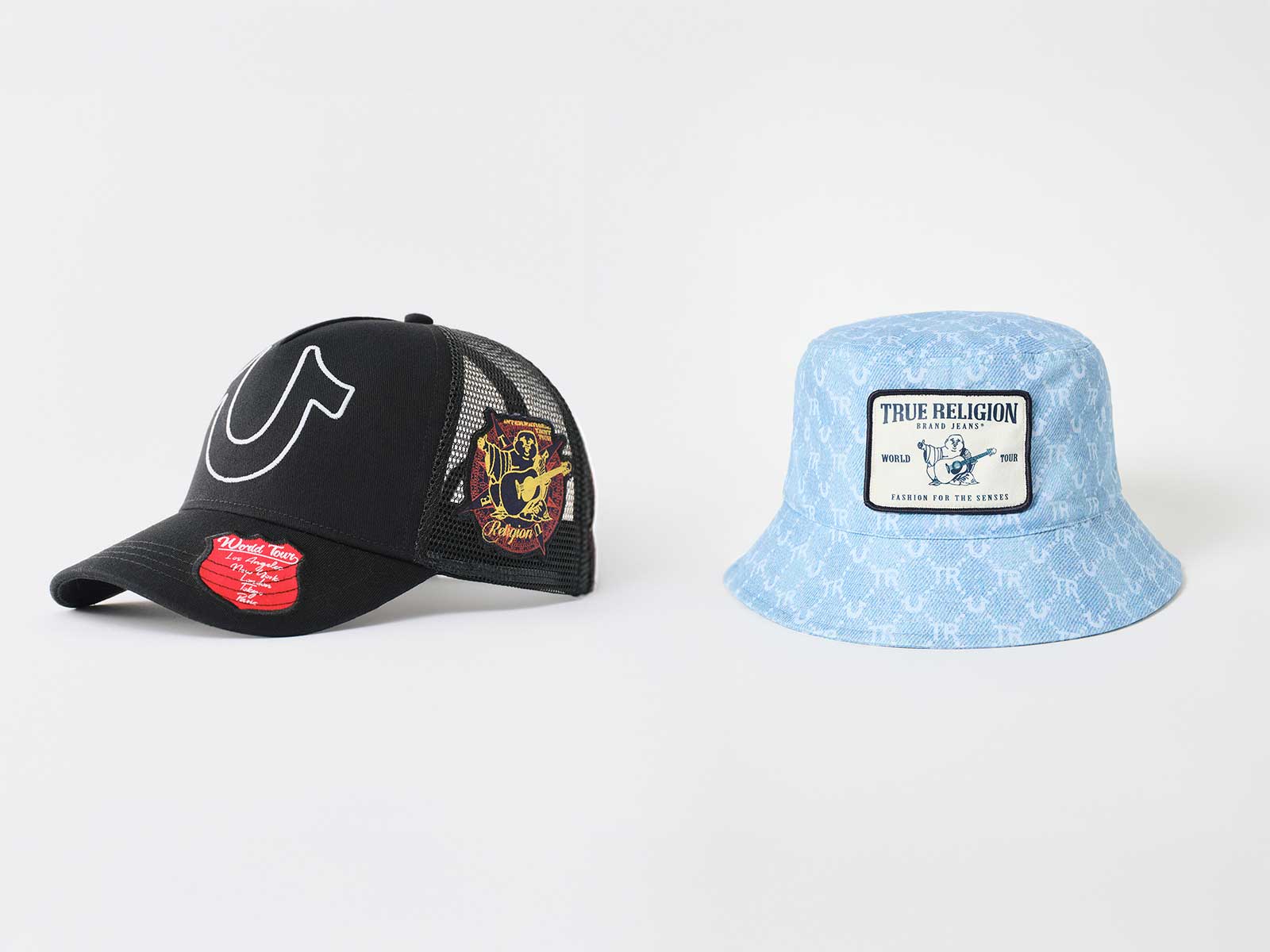 A black true religion trucker hat with horseshoe detailing and a baby blue bucket hat with buddha detailing