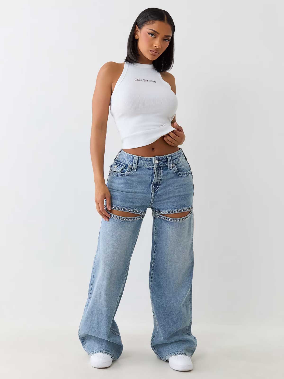 Woman wears true religion light wash baggy jeans with crystal cut outs