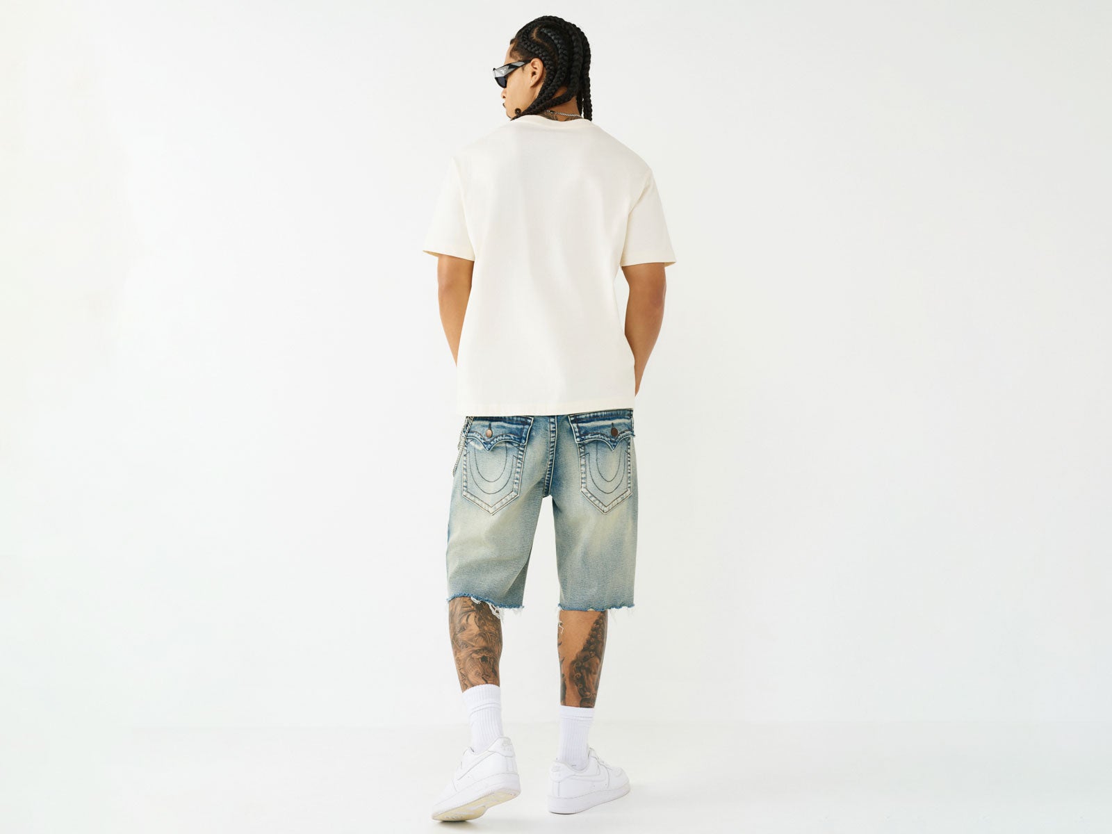 Back of man wearing baggy True Religion Jeans and white T-shirt